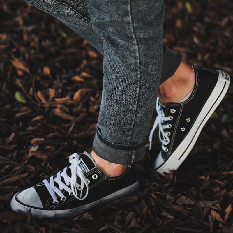 black and white Converse Low Top sneakers on the autumn leaves